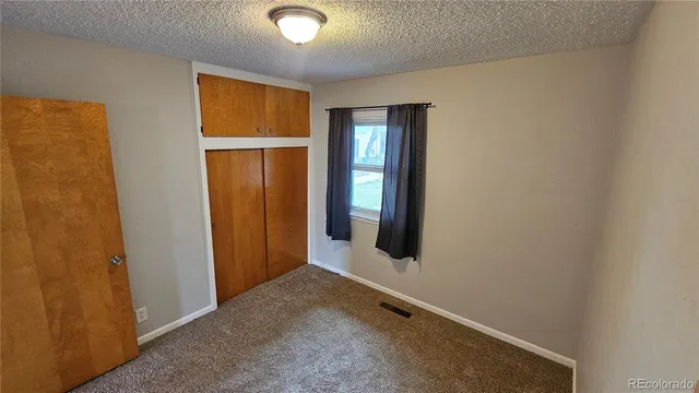 an empty room with windows and closet