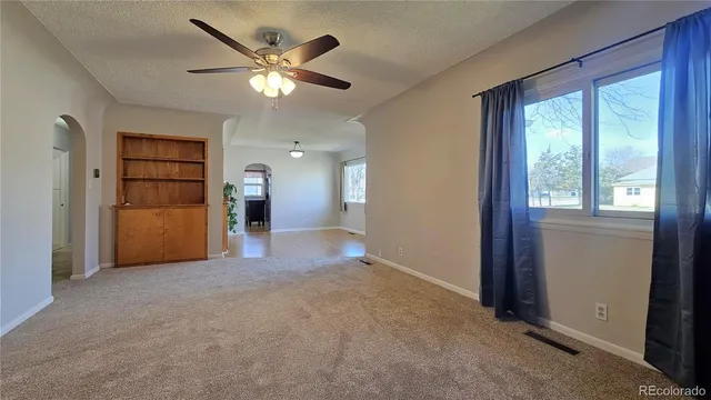 an empty room with closet and a ceiling fan