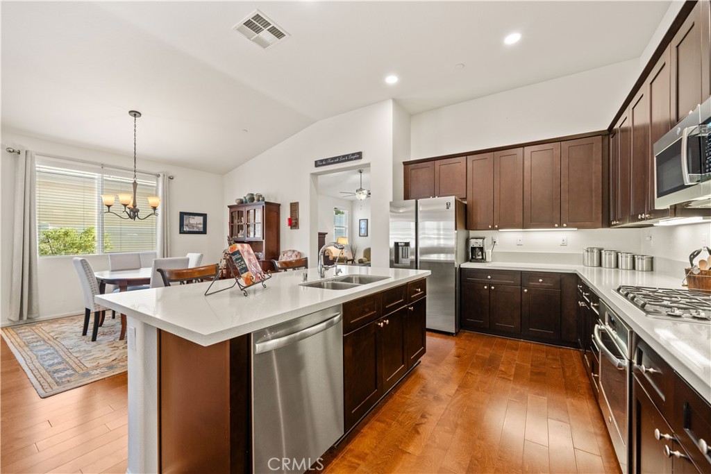 26519 Rim Creek Path Menifee, CA 92584 - Photo 18 of 45 a kitchen with sink a stove and chairs