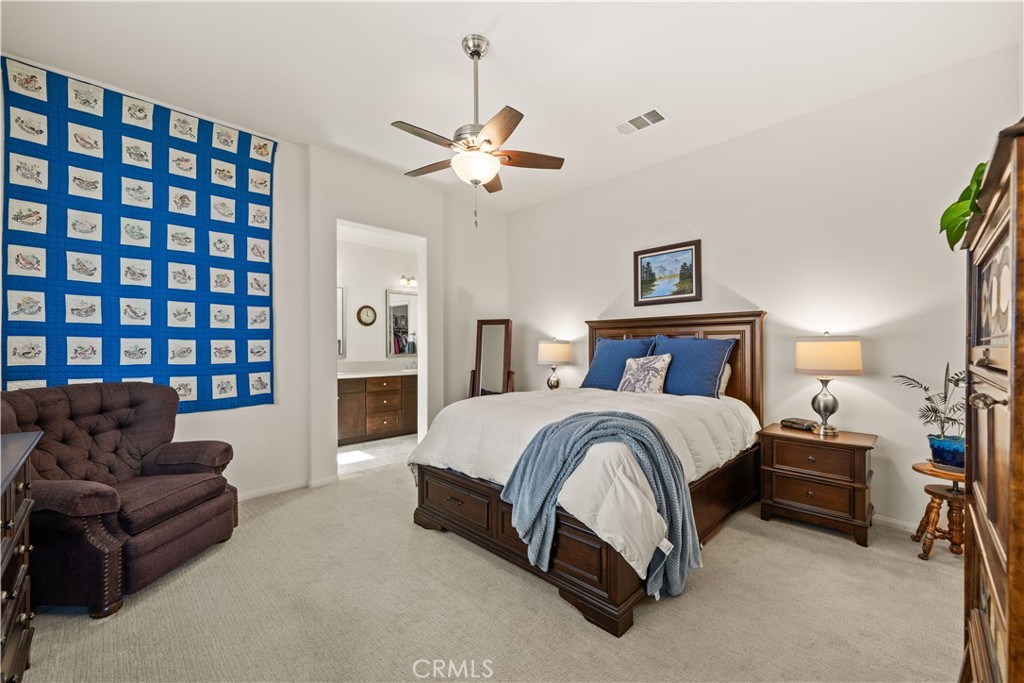 26519 Rim Creek Path Menifee, CA 92584 - Photo 26 of 45 a spacious bedroom with a bed couch and a window