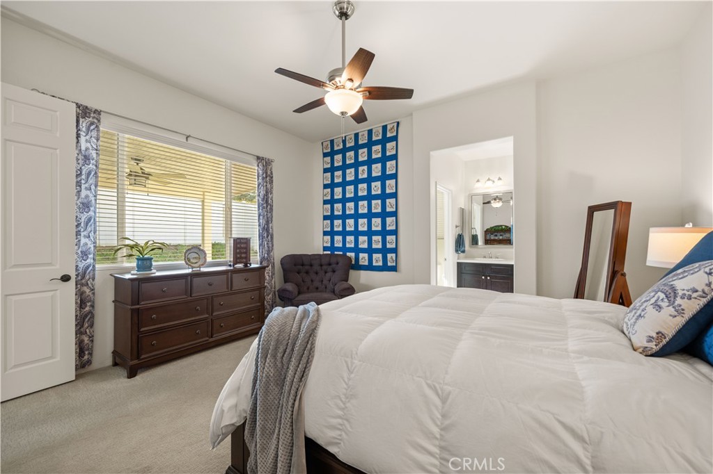 26519 Rim Creek Path Menifee, CA 92584 - Photo 27 of 45 a bed room with a bed and a chandelier