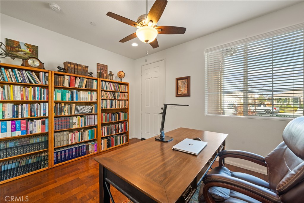 26519 Rim Creek Path Menifee, CA 92584 - Photo 10 of 45 a view of a workspace with furniture and a bookshelf