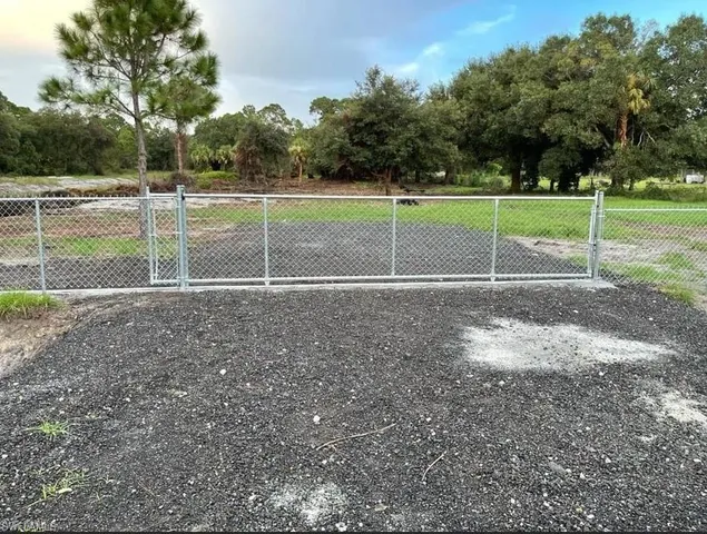 a view of a tennis ground with trees in the background
