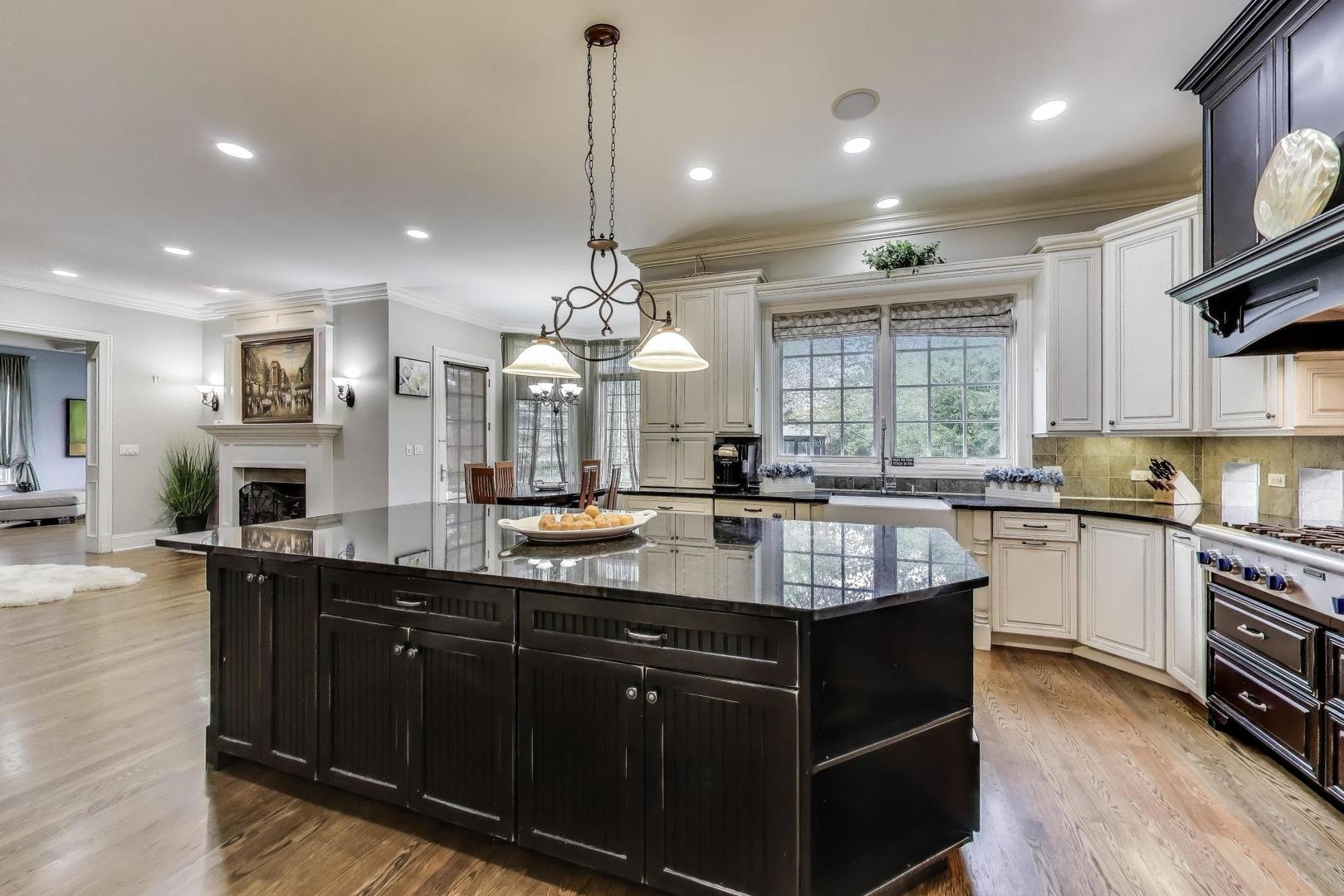 628 Greenwood Road Northbrook, IL 60062 - Photo 14 of 54 a kitchen with granite countertop kitchen island stainless steel appliances a sink stove and wooden floor