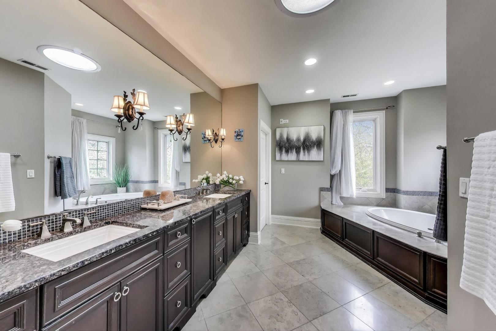 628 Greenwood Road Northbrook, IL 60062 - Photo 25 of 54 a large bathroom with a double vanity sink a large mirror and a bathtub