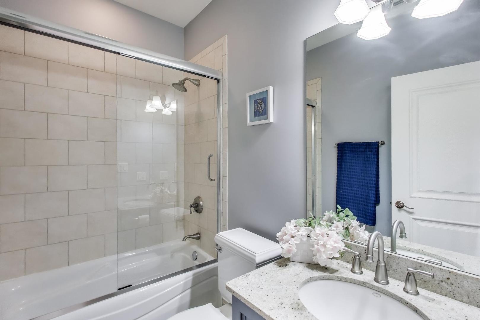 628 Greenwood Road Northbrook, IL 60062 - Photo 31 of 54 a bathroom with a granite countertop sink a toilet and shower