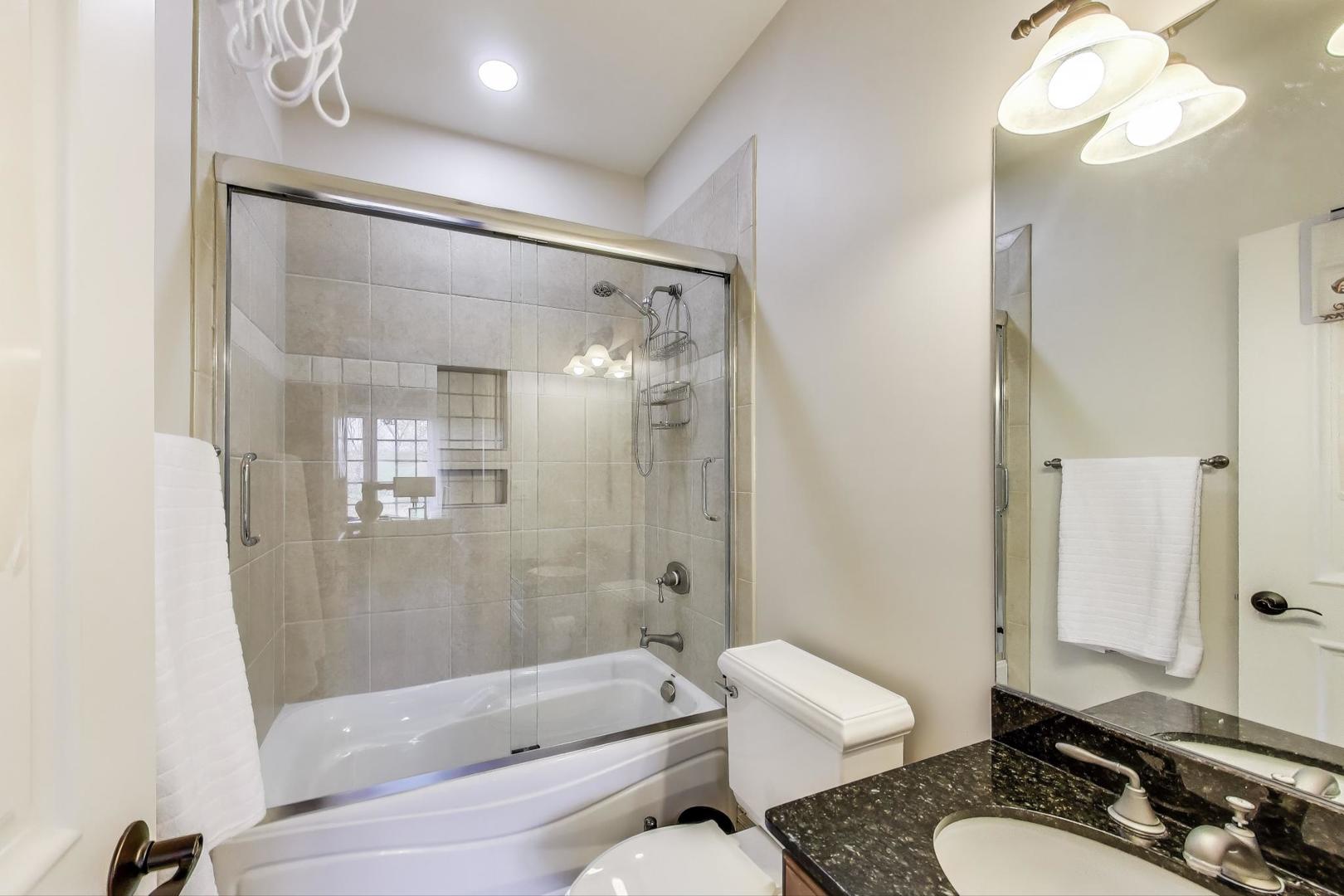 628 Greenwood Road Northbrook, IL 60062 - Photo 36 of 54 a bathroom with a granite countertop sink toilet a mirror and shower