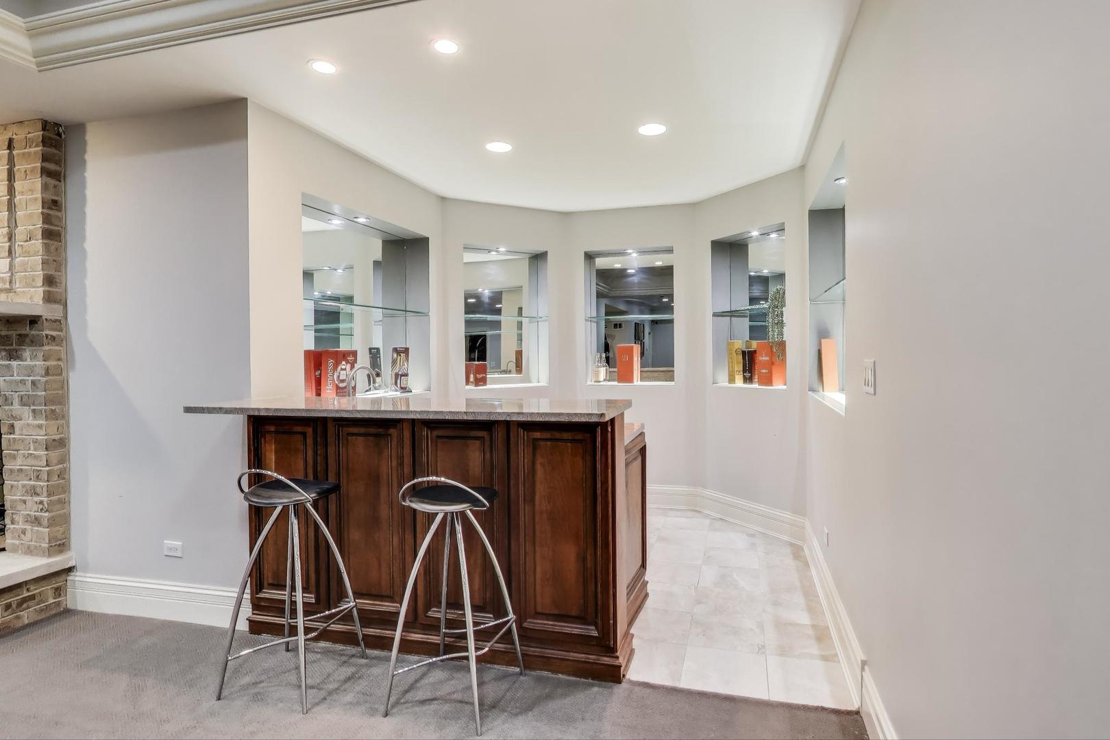 628 Greenwood Road Northbrook, IL 60062 - Photo 43 of 54 a dinning room with kitchen island a dining table chairs and mirrors