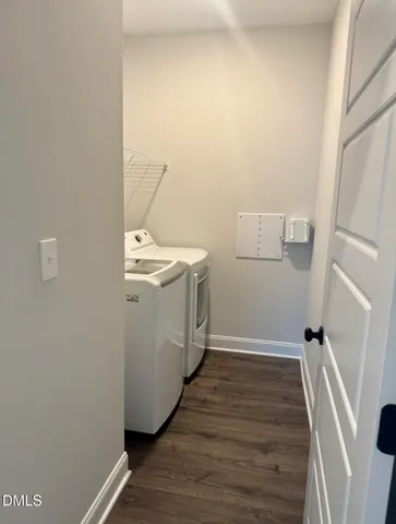 a utility room with wooden floor washer and dryer