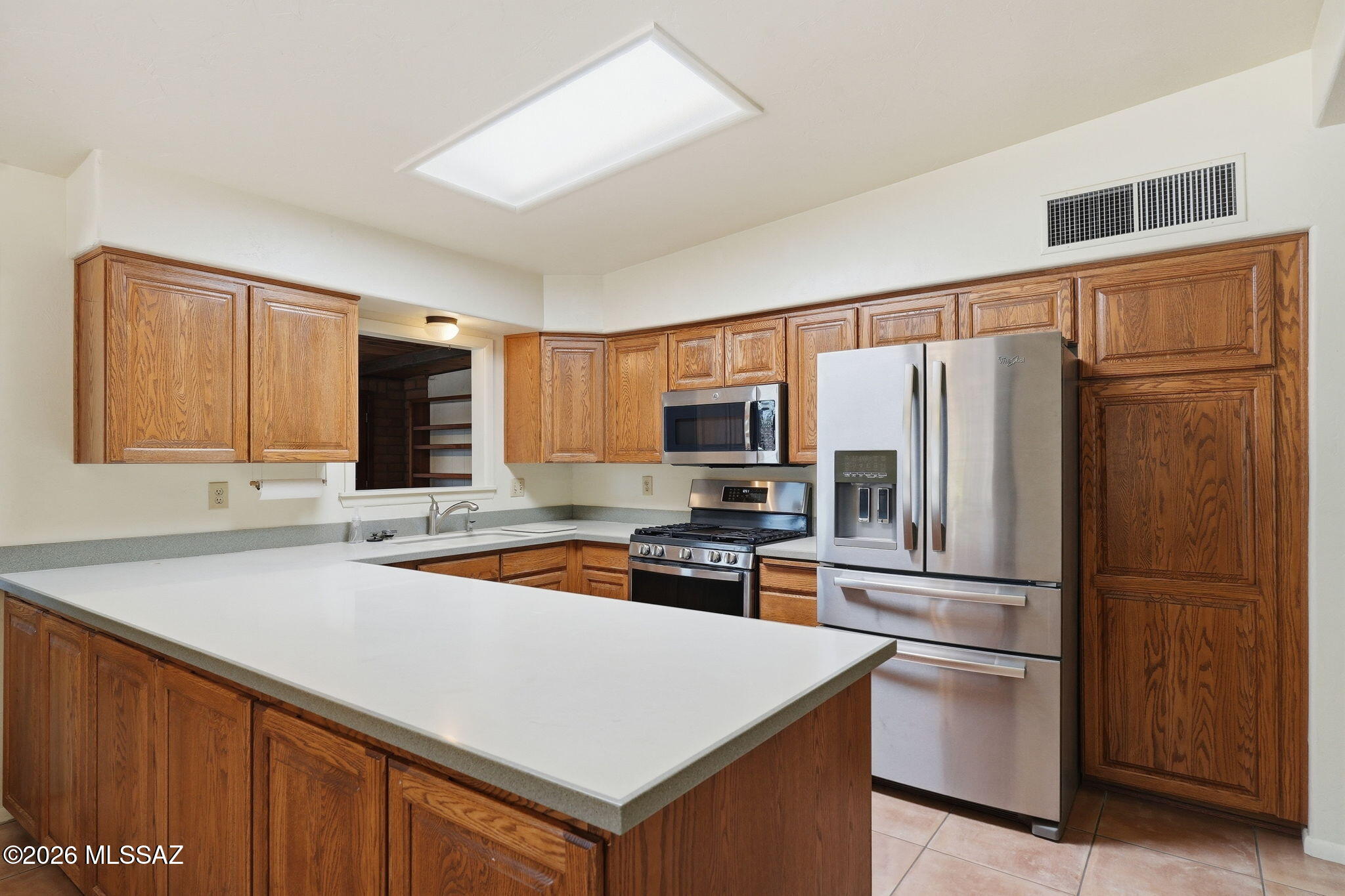 1125 East Kleindale Road Tucson, AZ 85719 - Photo 9 of 49 a kitchen with stainless steel appliances a refrigerator and a sink