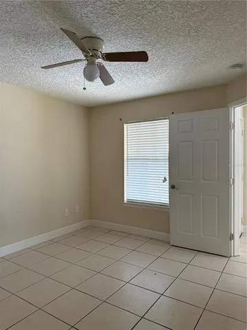 an empty room with a ceiling fan and window