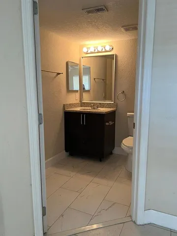 a view of living room with granite countertop and white cabinets