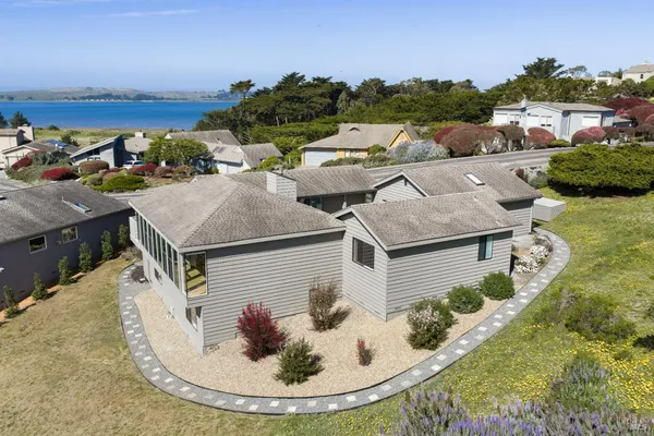 an aerial view of residential houses with outdoor space and trees