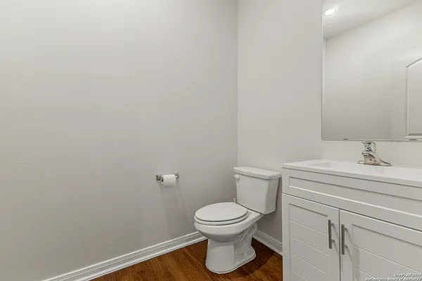 a bathroom with a toilet a sink and mirror