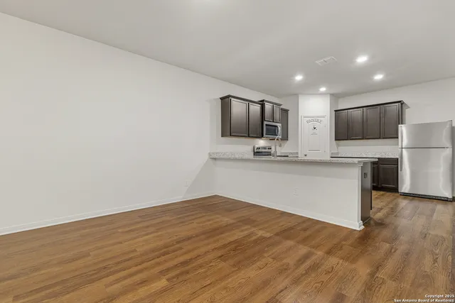 a large kitchen with a large counter top stainless steel appliances and cabinets