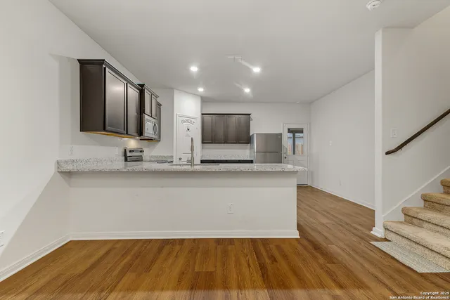 a view of kitchen with wooden floor and electronic appliances