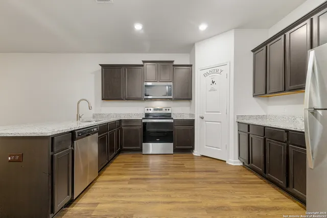 a kitchen with stainless steel appliances granite countertop a stove a sink and a refrigerator