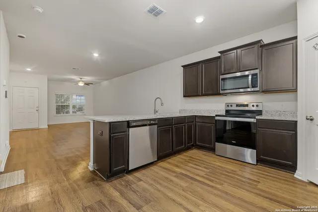 a kitchen with stainless steel appliances kitchen island granite countertop a stove a sink and a microwave