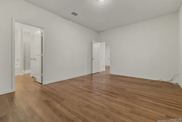 a view of an empty room and wooden floor