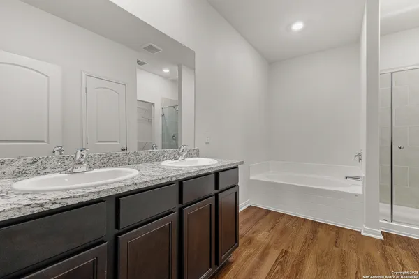 a bathroom with a granite countertop sink mirror and a bath tub