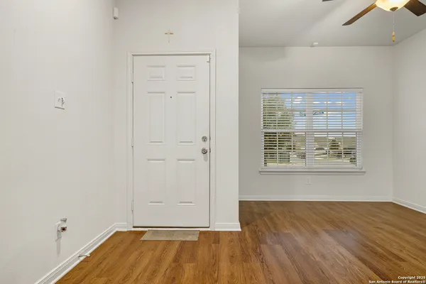 an empty room with wooden floor and windows