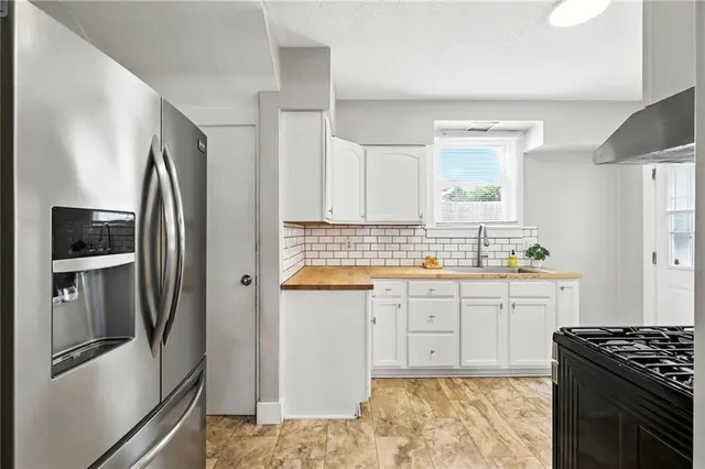 a kitchen with granite countertop a refrigerator stove and sink