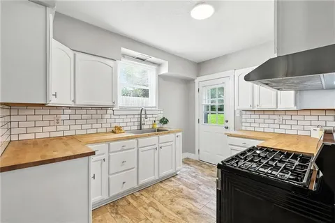 a kitchen with sink stove and cabinets