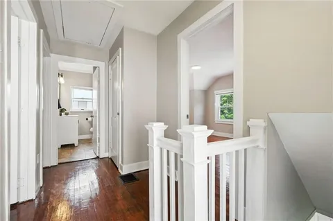 a view of a hallway with wooden floor and stairs