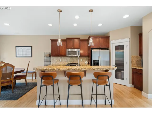 a kitchen with stainless steel appliances granite countertop sink stove and wooden floor