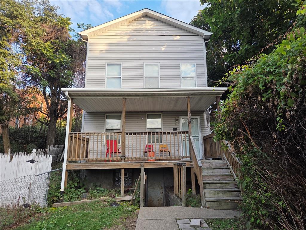a front view of house with yard and trees around