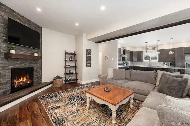a living room with furniture a flat screen tv and a fireplace