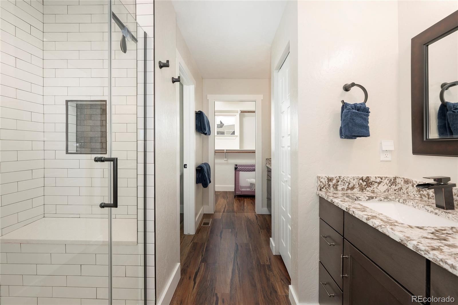 719 Saddle Ridge Circle Granby, CO 80446 - Photo 21 of 47 a bathroom with a granite countertop sink a mirror and shower