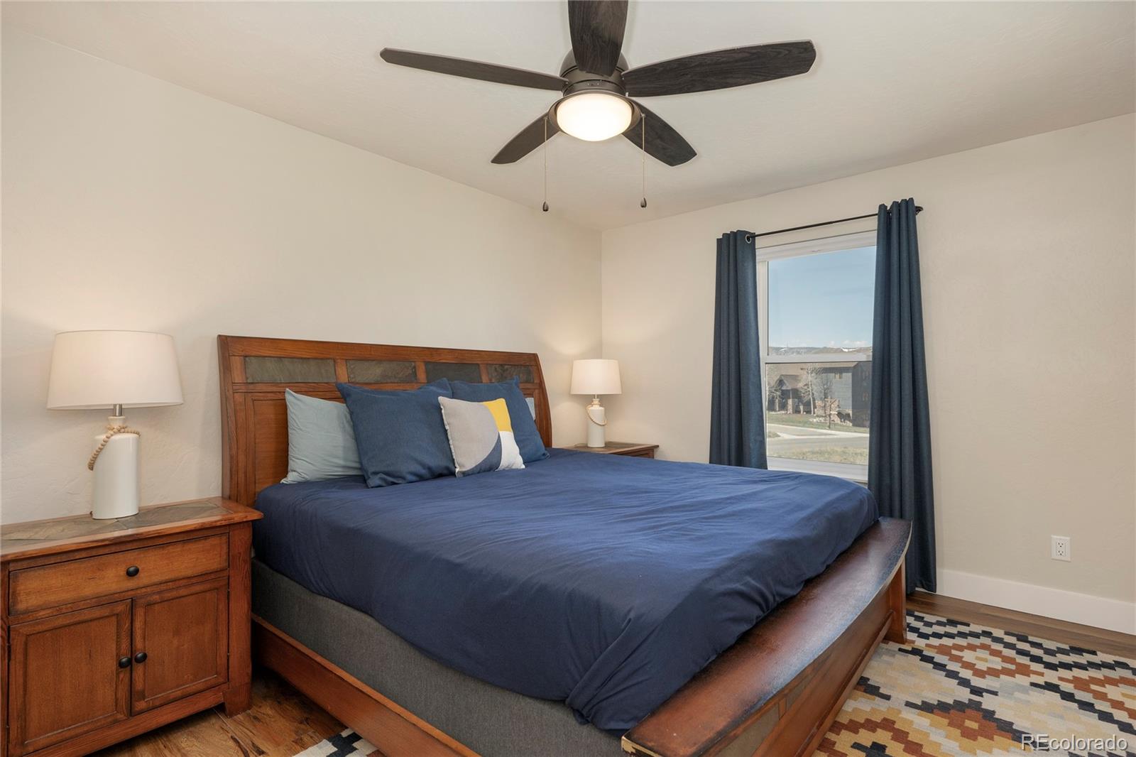 719 Saddle Ridge Circle Granby, CO 80446 - Photo 24 of 47 a bedroom with a large bed and a chandelier