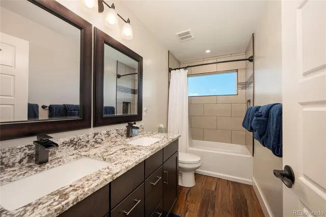 a bathroom with a granite countertop sink toilet and shower