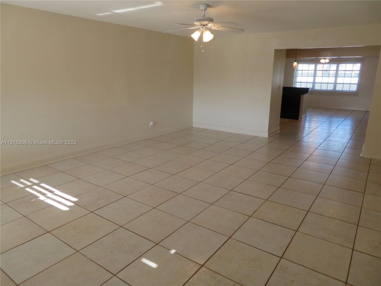 3000 Northeast 19th Terrace, Unit B Lighthouse Point, FL 33064 - Photo 2 of 2 an empty room with chandelier fan and windows