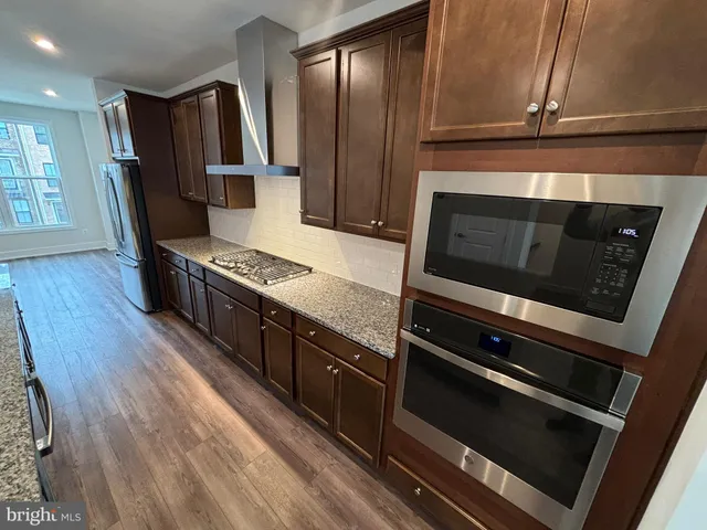 a kitchen with granite countertop stainless steel appliances and wooden cabinets