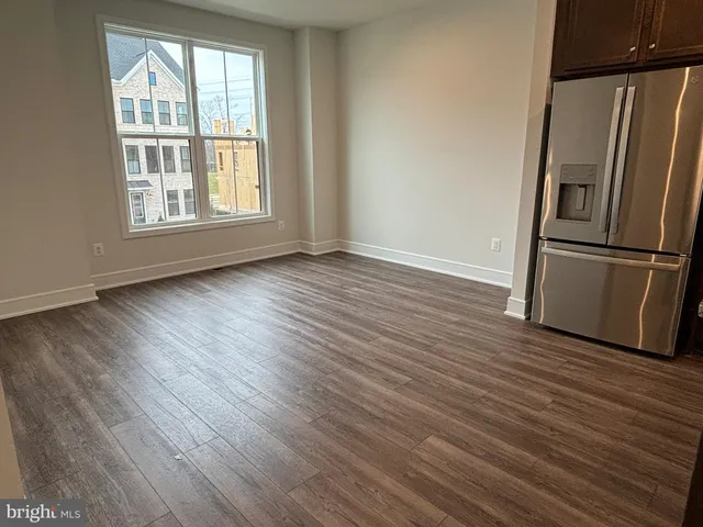 a view of a kitchen with wooden floor and a refrigerator