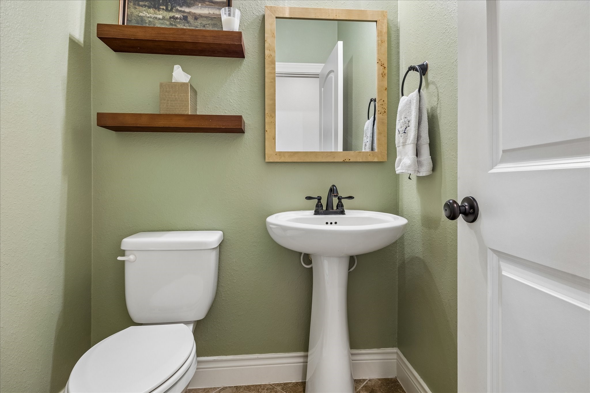 1616 Hewitt Drive Houston, TX 77018 - Photo 12 of 44 Convenient powder bath features pedestal sink, floating wood shelves, and warm accent paint that adds character to the space.