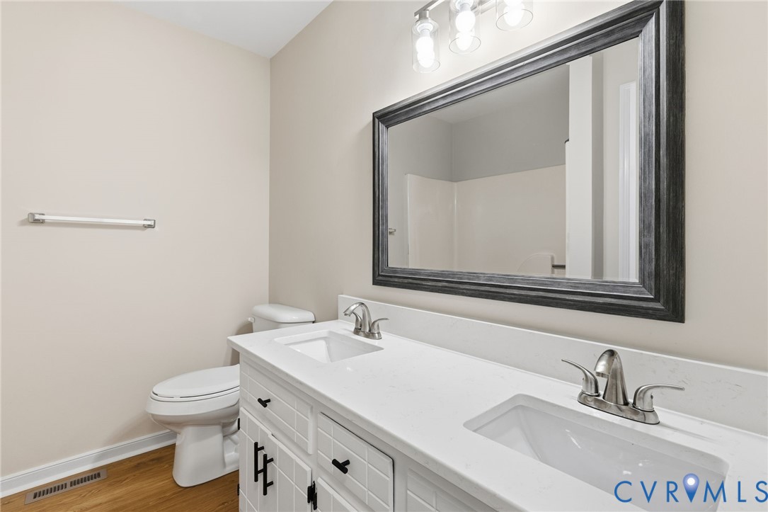 8736 Sunset Knoll Road Richmond, VA 23237 - Photo 16 of 26 a bathroom with a toilet sink and mirror