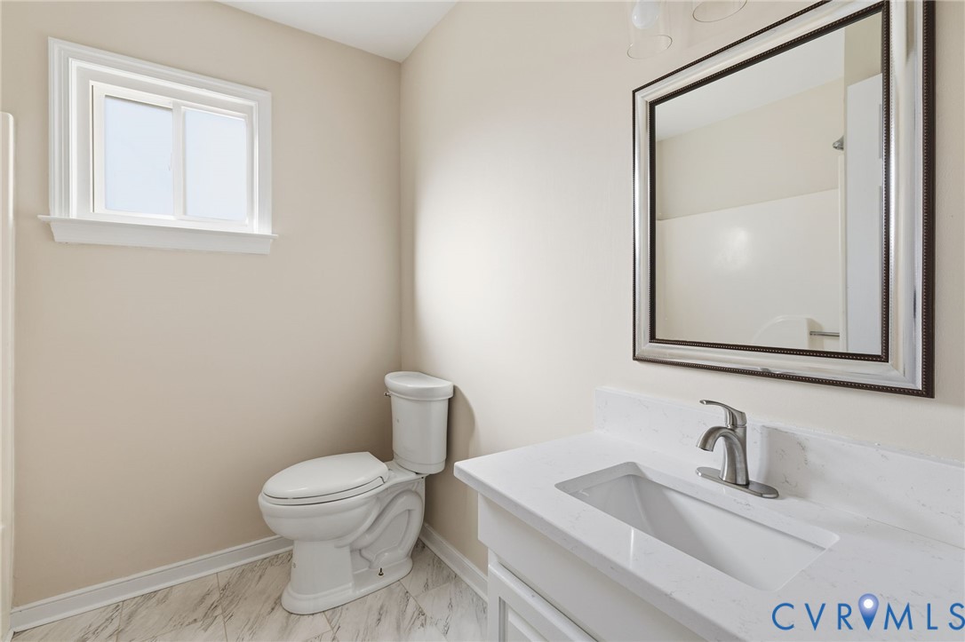 8736 Sunset Knoll Road Richmond, VA 23237 - Photo 21 of 26 a bathroom with a toilet sink vanity and mirror