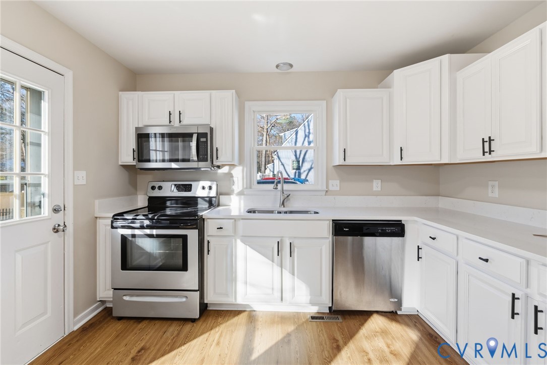 8736 Sunset Knoll Road Richmond, VA 23237 - Photo 4 of 26 a kitchen with stainless steel appliances a stove a sink and a microwave