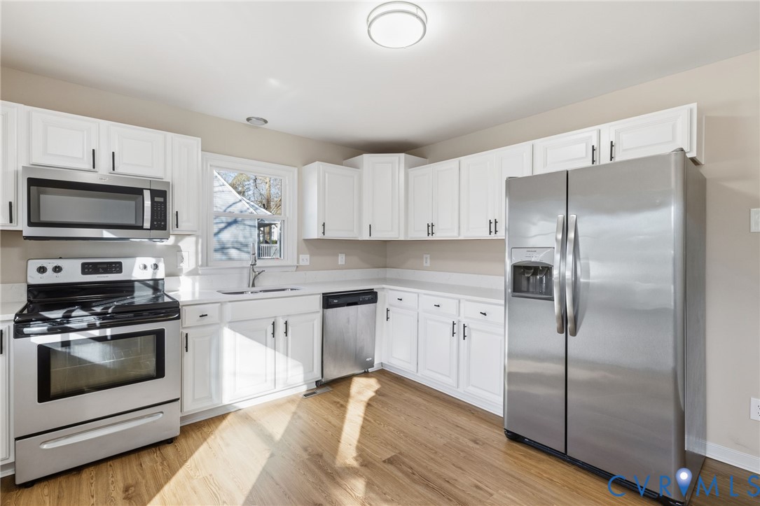 8736 Sunset Knoll Road Richmond, VA 23237 - Photo 5 of 26 a kitchen with a refrigerator stove and microwave