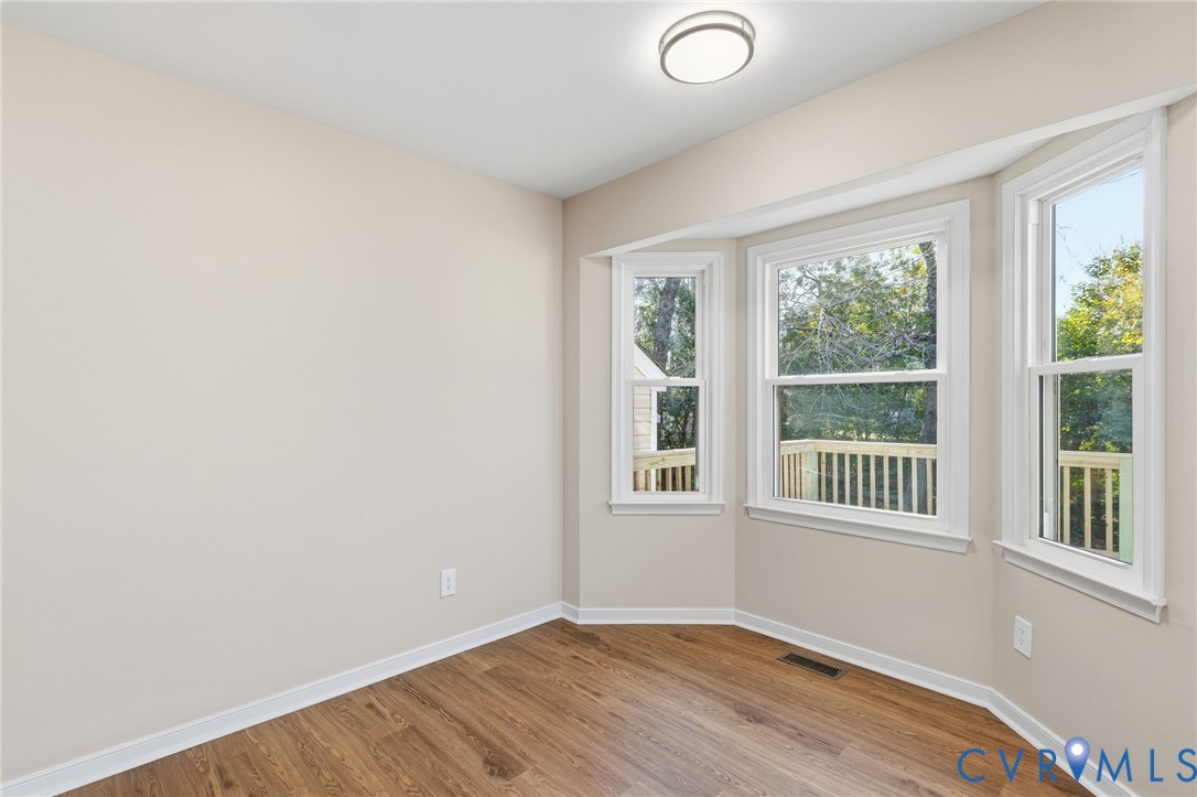 8736 Sunset Knoll Road Richmond, VA 23237 - Photo 7 of 26 an empty room with wooden floor and windows