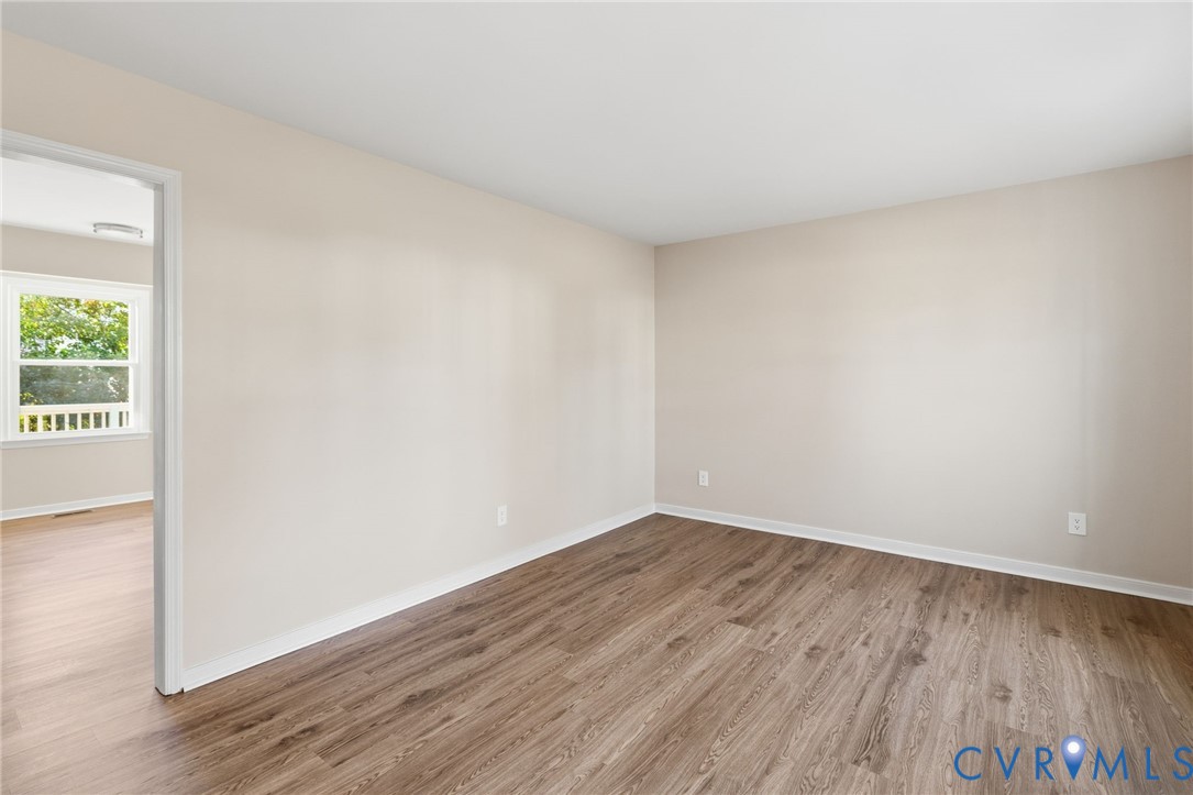 8736 Sunset Knoll Road Richmond, VA 23237 - Photo 9 of 26 a view of an empty room with wooden floor and a window