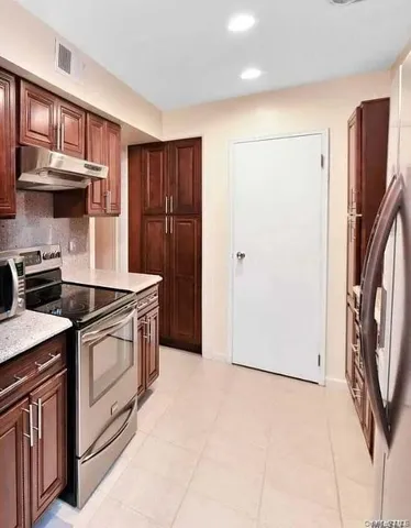 a kitchen with stainless steel appliances granite countertop a stove a refrigerator and a refrigerator