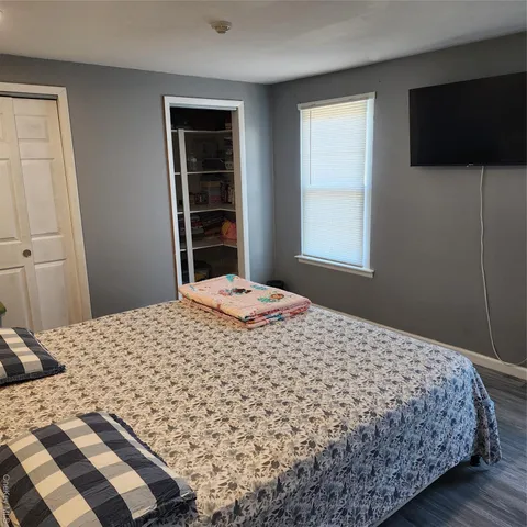 a bedroom with a bed and a flat screen tv
