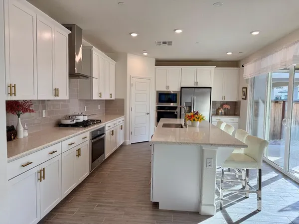 a kitchen with kitchen island granite countertop wooden cabinets and white appliances