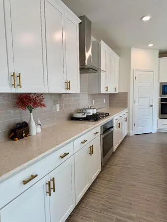 a kitchen with stainless steel appliances granite countertop a sink a stove and cabinets