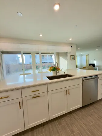 a kitchen with white cabinets white appliances and sink