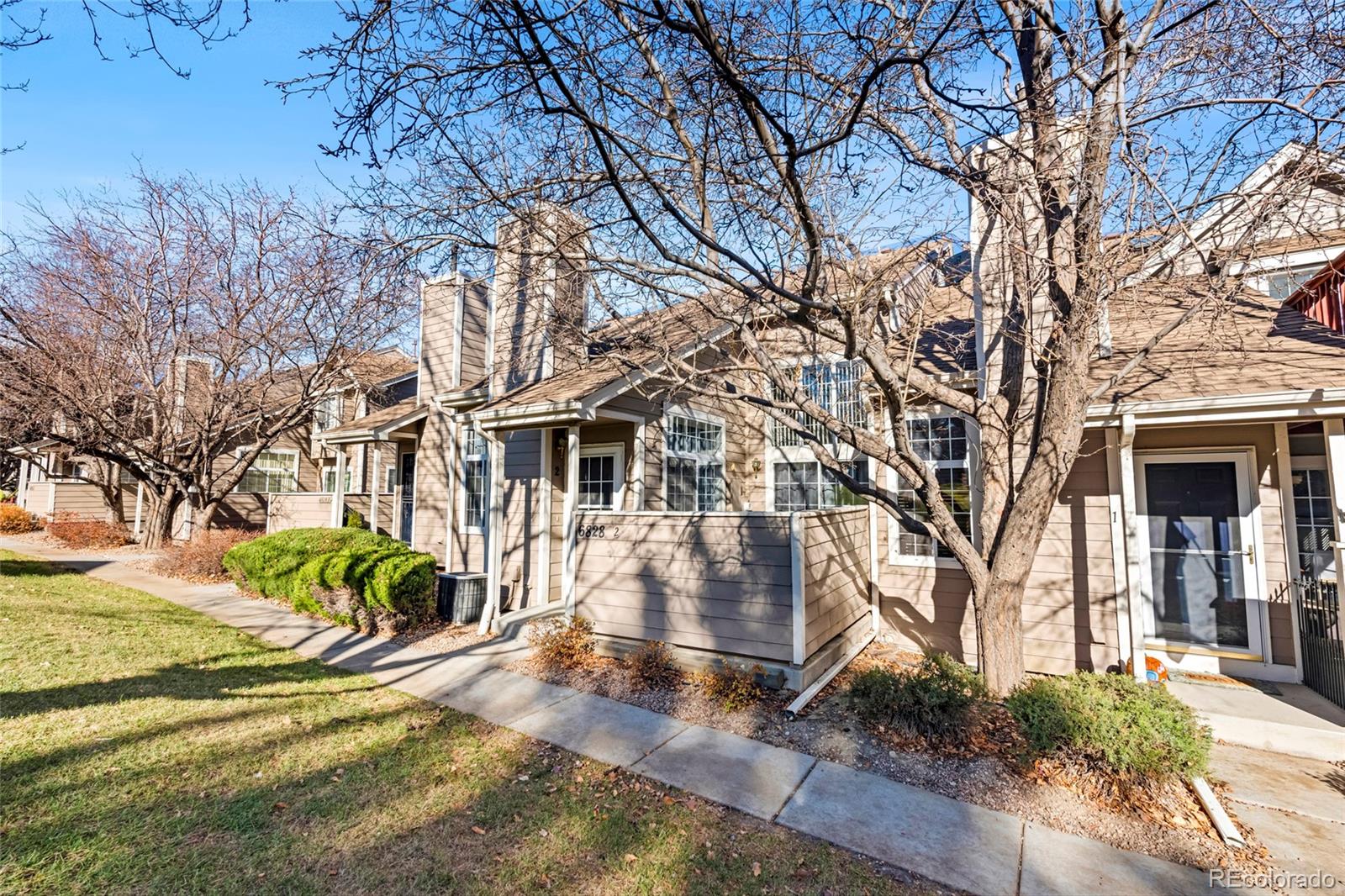 6828 Zenobia Street, Unit 2 Westminster, CO 80030 - Photo 23 of 24 a view of a white house with a yard covered in snow